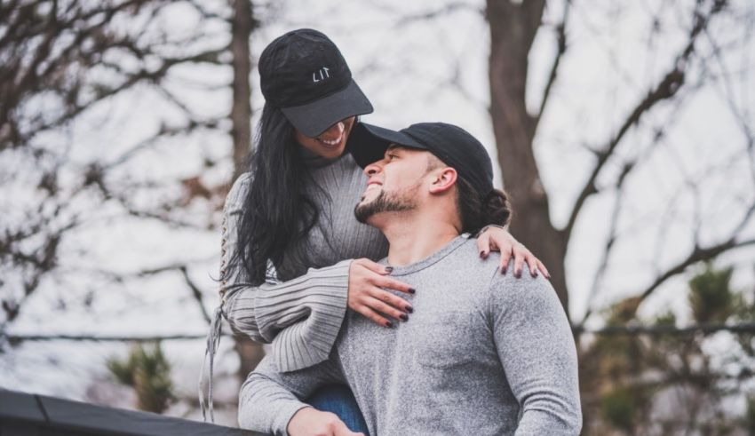 A man and woman hugging in front of a tree.