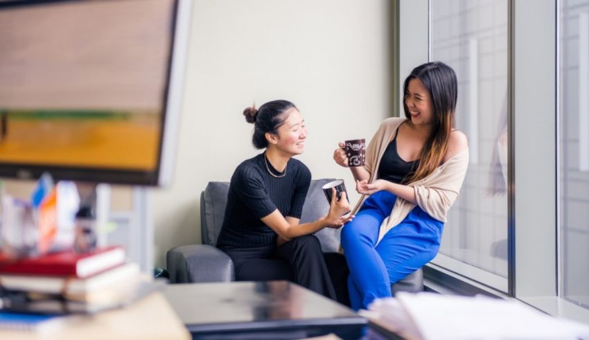 Two women sitting on a chair.