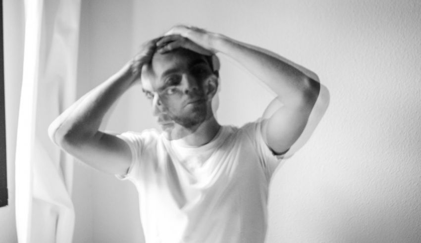 A black and white photo of a man holding his head up.