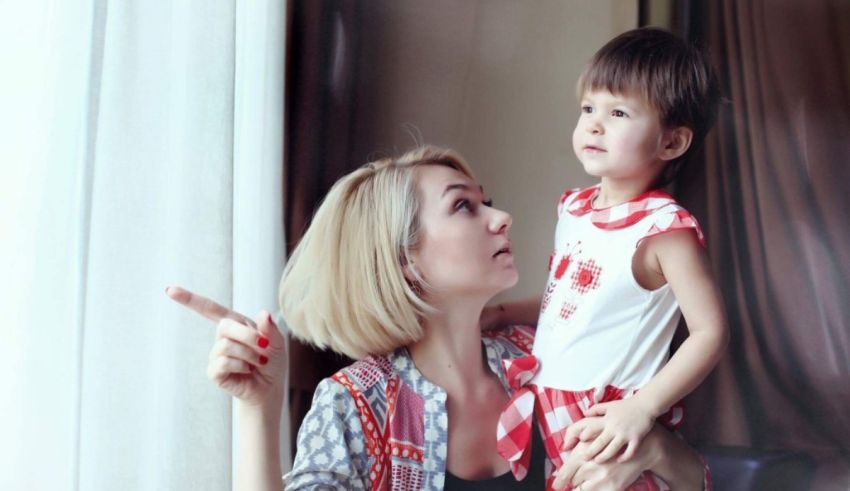 A woman and a child looking out of a window.