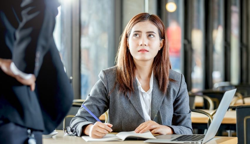 A woman sitting at a table with a laptop and a notebook.