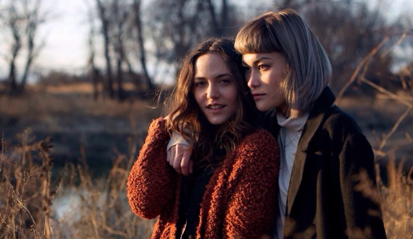 Two women standing next to each other in a field.