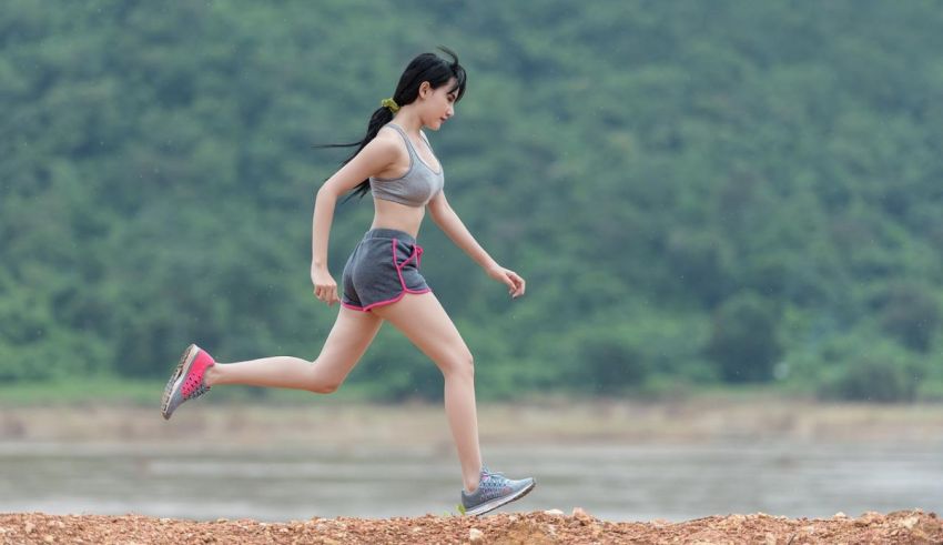 A woman jogging near a river.