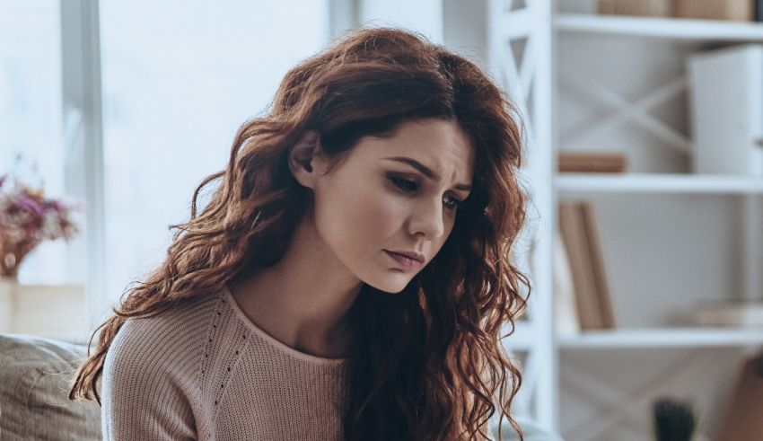 A woman sitting on a couch looking at her laptop.