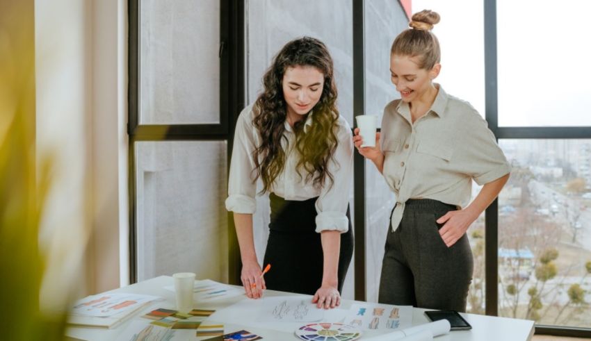 Two business women working together at a desk in an office.