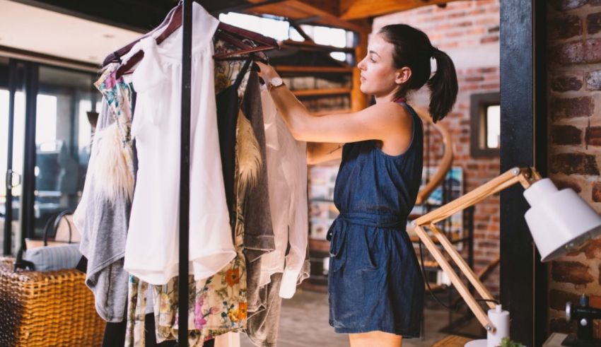 A woman is putting clothes on a rack in her home.