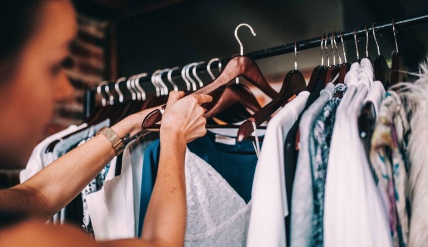 A woman is putting clothes on a rack.