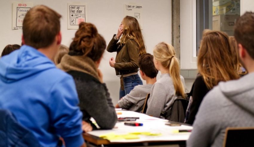A group of people sitting at a desk in a classroom.
