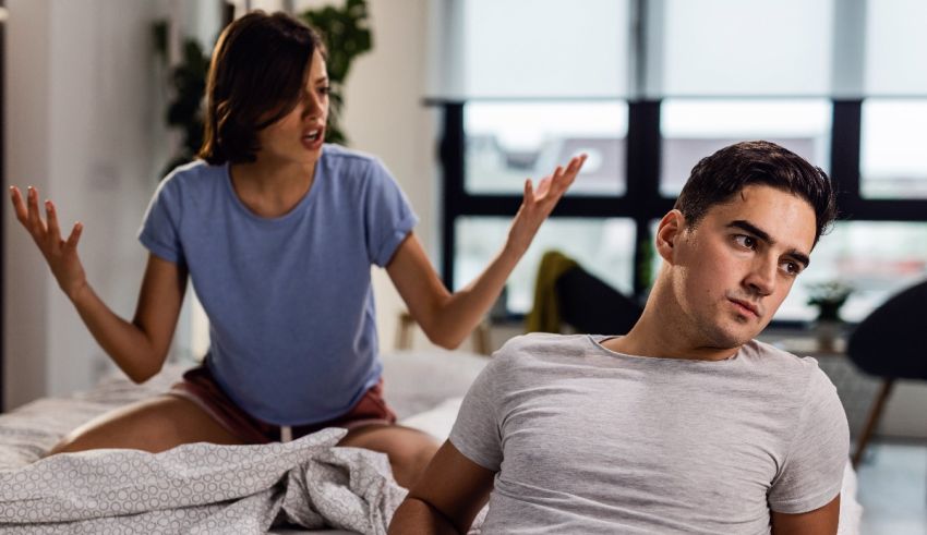 A man and woman arguing on the bed.