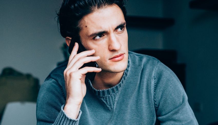 A man talking on a cell phone while sitting at a table.