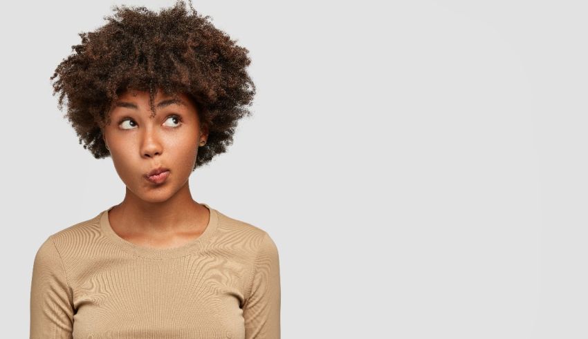 A young woman with afro hair looking surprised.