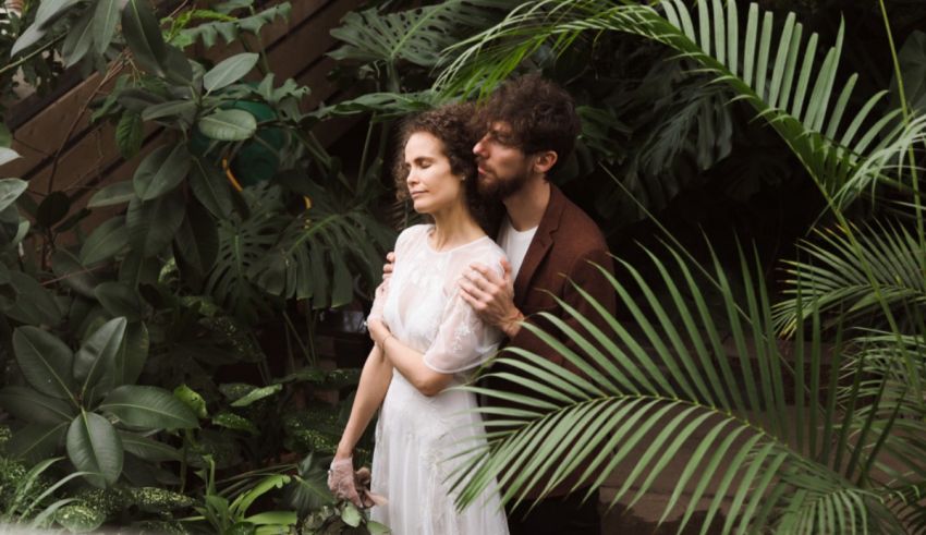 A bride and groom hugging in a tropical garden.