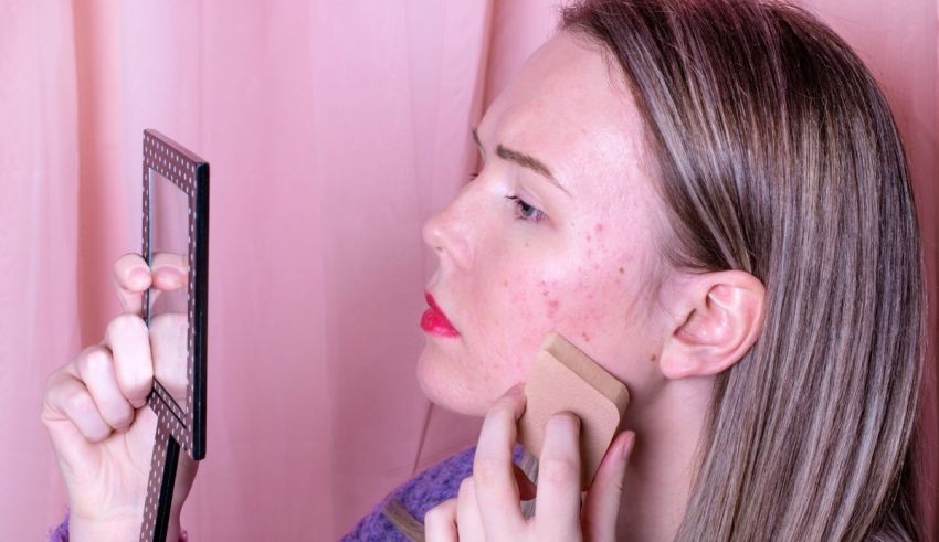 A woman applying makeup to her face in front of a mirror.