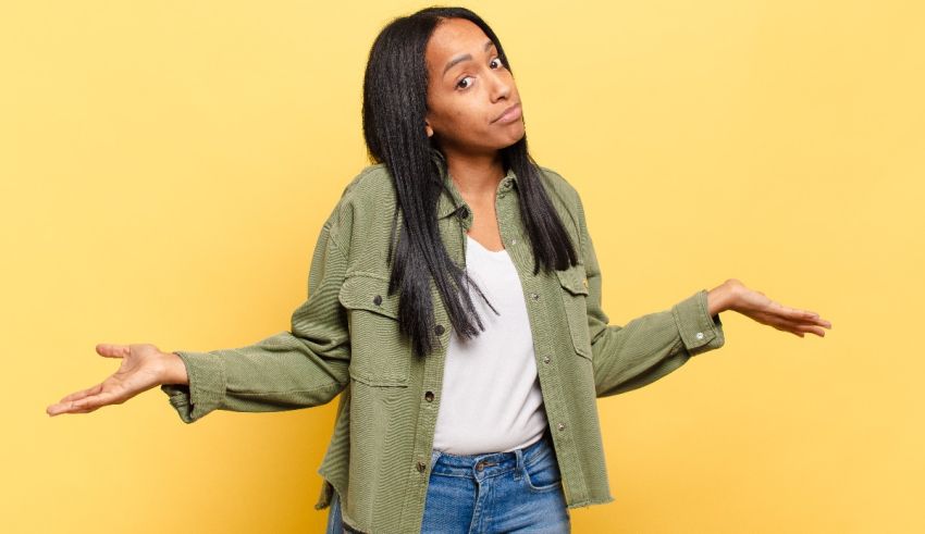 A young african american woman with her arms outstretched against a yellow background.