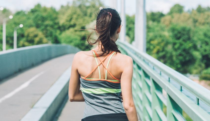 A woman is jogging on a bridge.