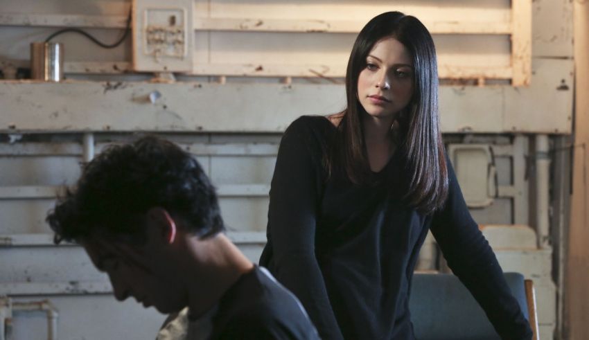 A woman is standing next to a man in a room.