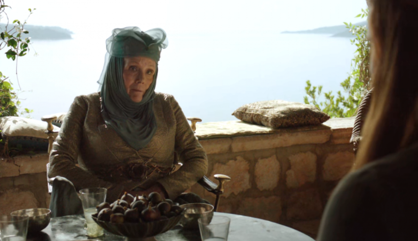A woman is sitting at a table and talking to someone.