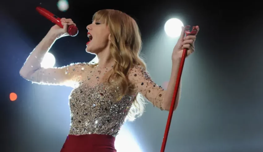 Taylor swift performs on stage with a microphone.